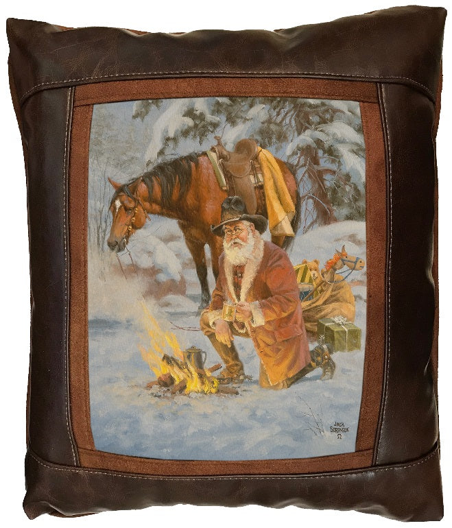 Decorative pillow with a winter scene of a vintage Santa and horse by a fire, framed in brown leather.
