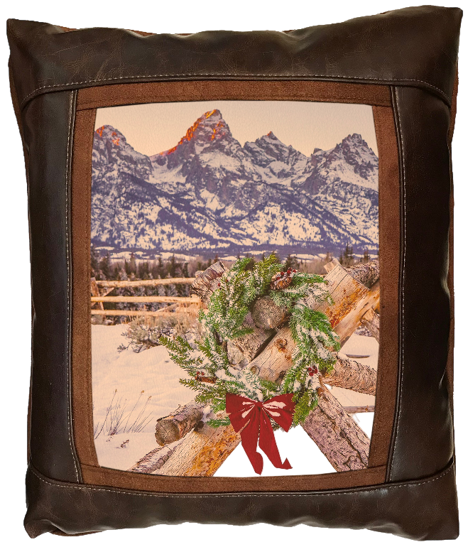 Decorative pillow with mountain and log design on a brown leather background