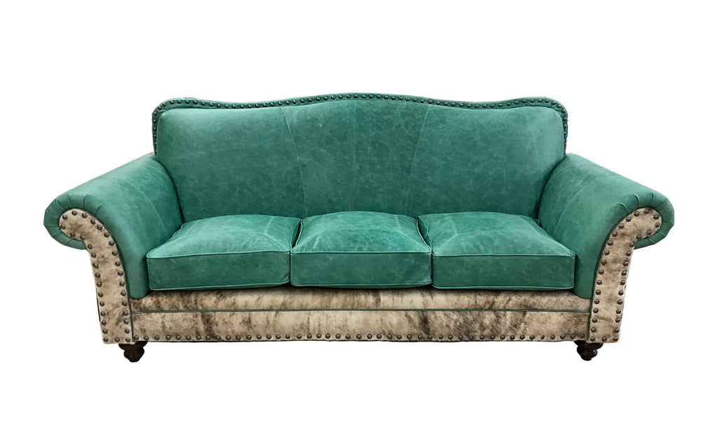 Green sofa in a warehouse setting with various items in the background
