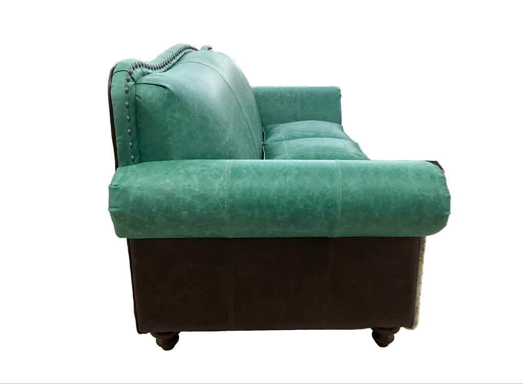 Green sofa in a warehouse setting with people and equipment around