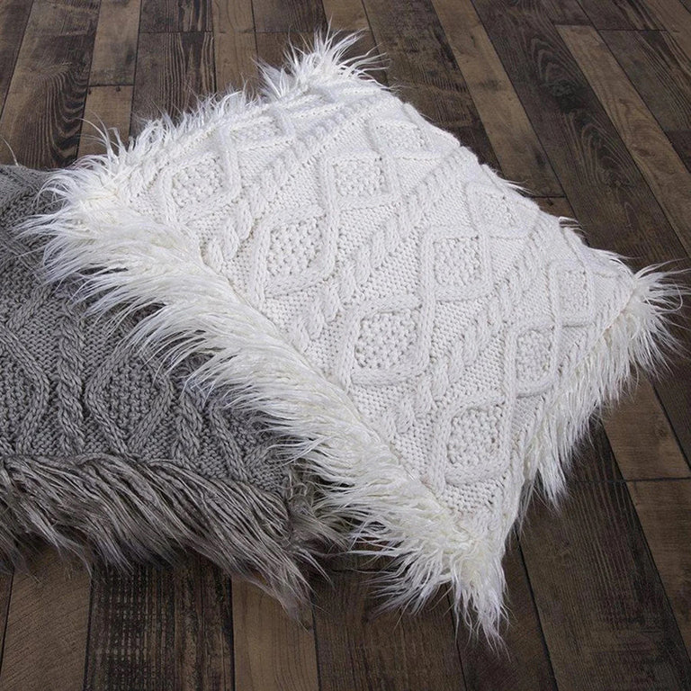 White textured pillow with faux fur trim on top of gray textured pillow with faux fur trim on a wooden floor
