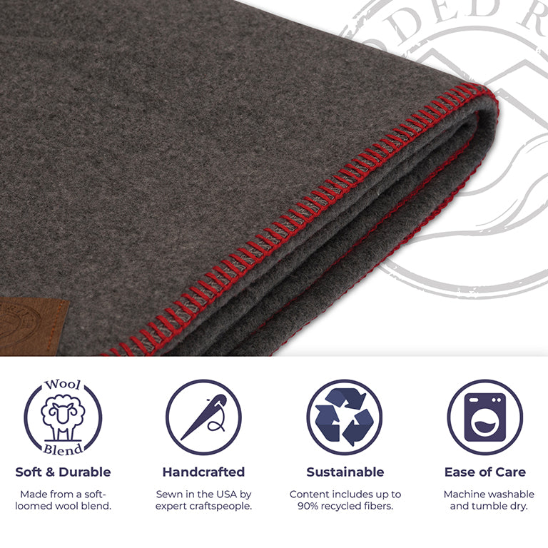 Gray wool blanket with red stitching on a white background, featuring sustainability and care instructions.