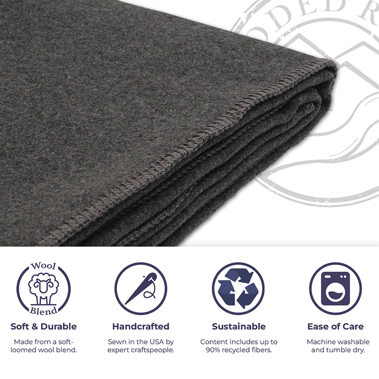 Folded dark gray wool blanket with sustainability and care instructions on a white background