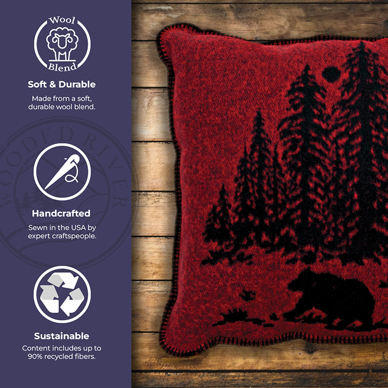 Red pillow with bear and tree design on a wooden surface, with sustainability and craftsmanship details.