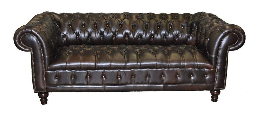 Brown leather sofa with tufted backrest, tufted bench seat and rolled arms on a white background.