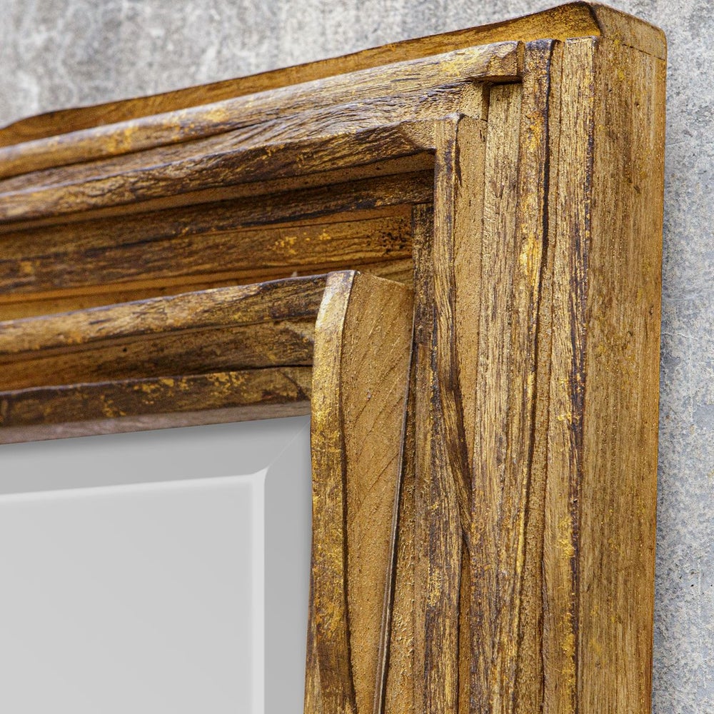close up of corner of mirror that shows raw layers of curved teackwood finished in distressed antique gold mirror frame