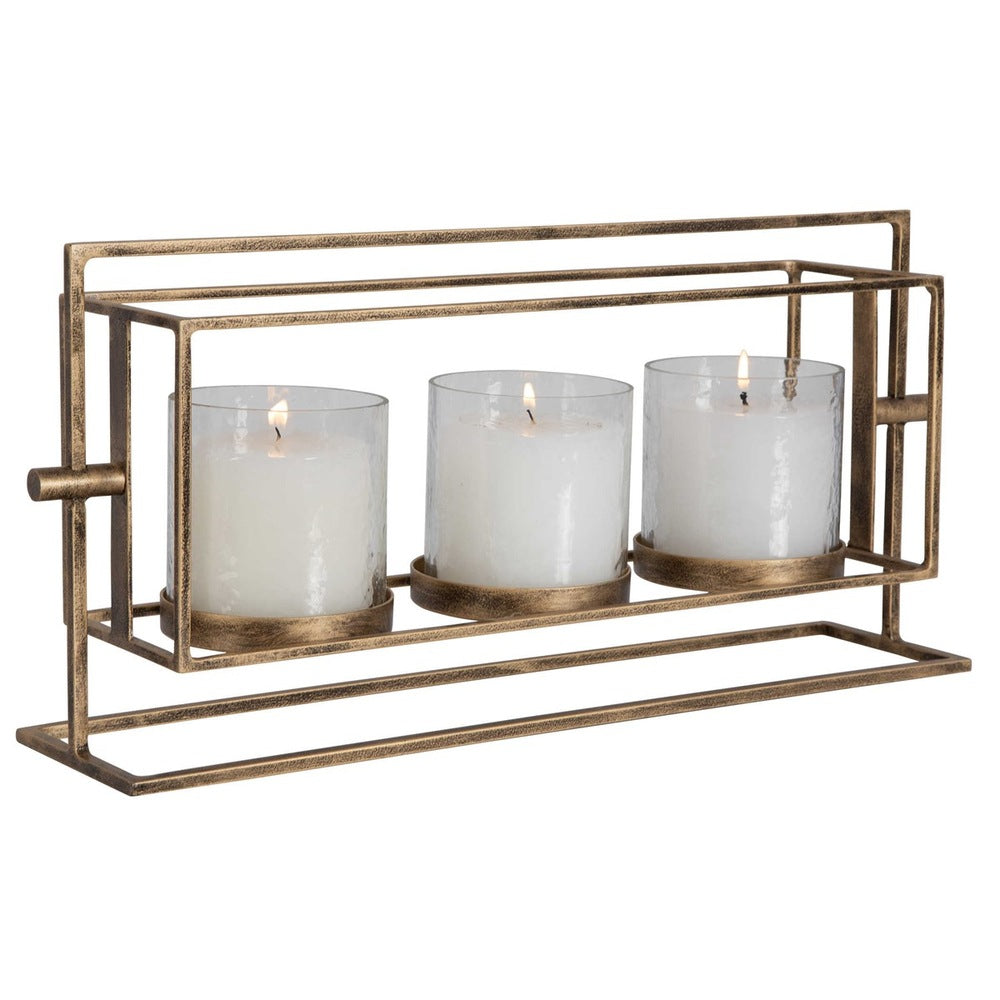 Lantern with textured clear glass hurricanes and an antique gold iron stand, accommodating three white pillar candles for a cozy ambiance.
