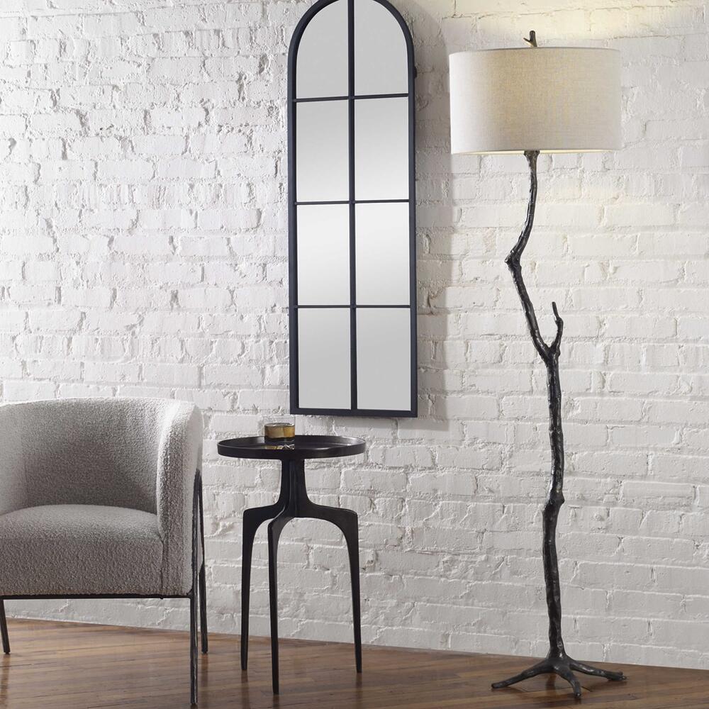 Floor lamp with a handcrafted tree branch-inspired cast iron frame, featuring distressed black tones and a subtle silver finish.