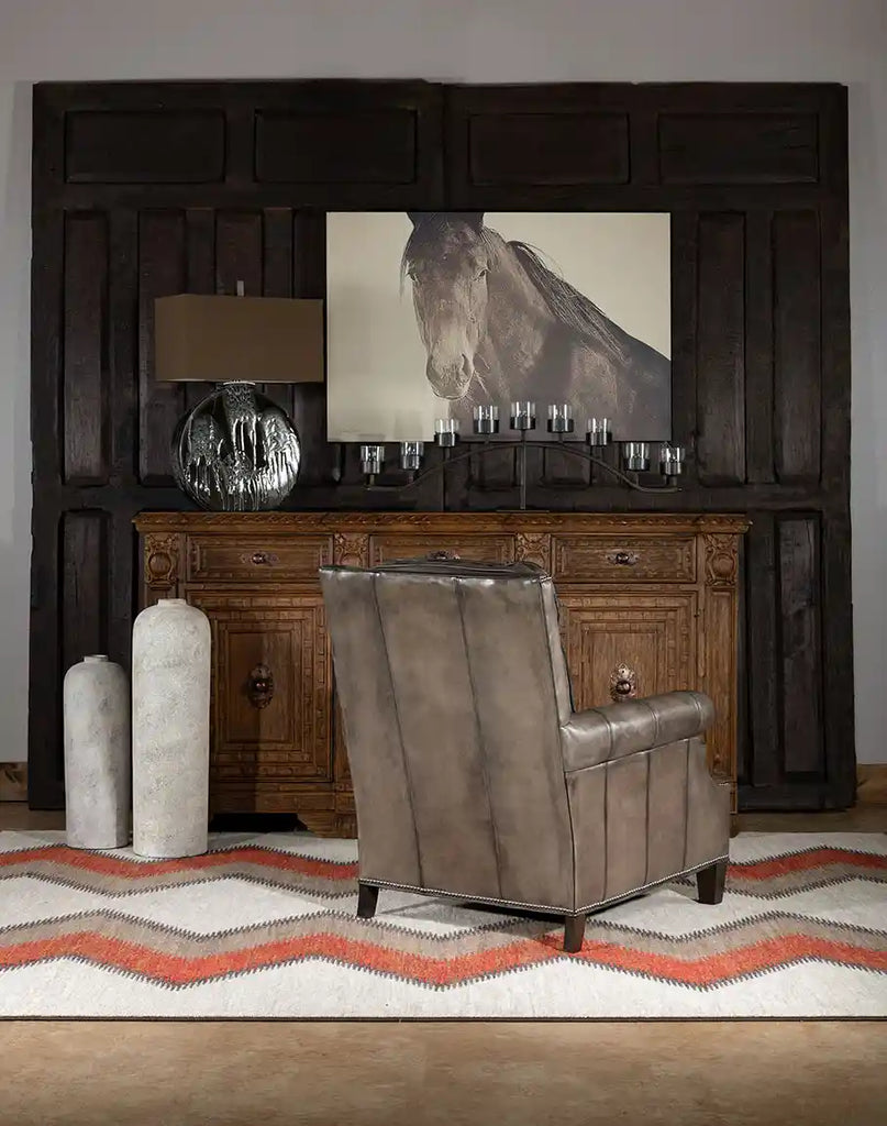 The back view of Ashton Leather Chair placed in a living room environment, complementing both rustic and elegant decor styles.