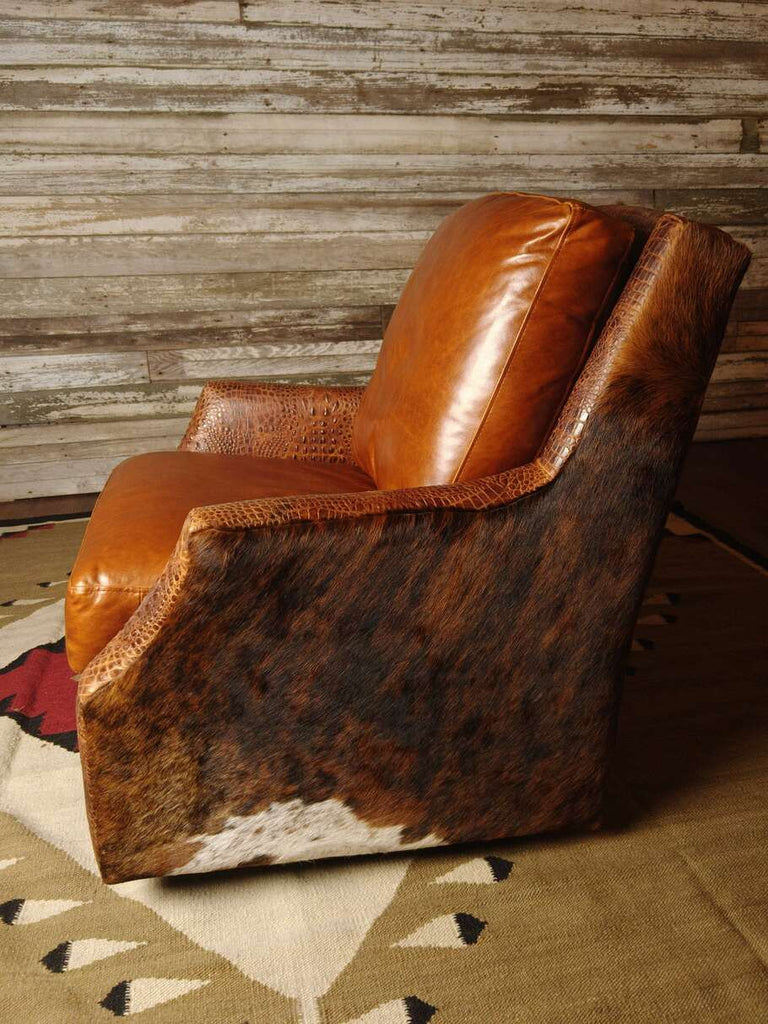 A side view of the Bedford Cowhide Swivel Glider, showcasing its sleek design, Gator Hornback Rustic Cognac leather accents, and smooth swivel base.