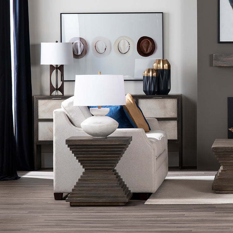 Modern living room with a gray sofa, decorative pillows, and a geometric side table.
