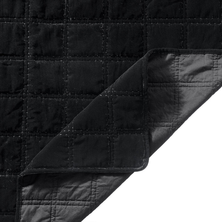 Close-up of the quilt's corner, displaying the precise stitching and plush velvet texture in a soothing black shade.