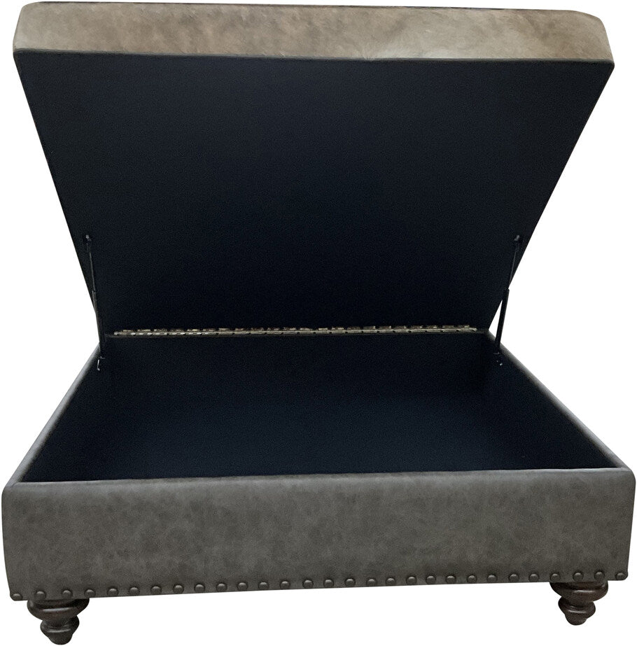 The Brazilian Cowhide Storage Ottoman with its lid open, revealing a spacious interior for storage, lined with high-quality materials for durability.