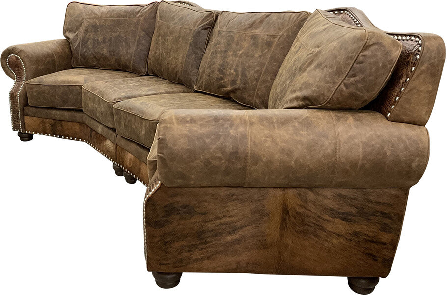 A luxurious Brown Apachean Curved Sectional upholstered in Cora Sierra leather with Gator Hornback Rustic Cognac accents, featuring plush cushions, rolled arms, nailhead trim, and exotic cowhide-wrapped sides and back.