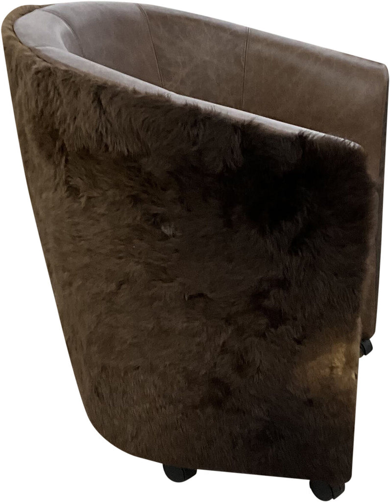 Side profile of the Buffalo Poker Chair displaying its curved arms wrapped in authentic buffalo hide and its handcrafted details that enhance comfort and durability.