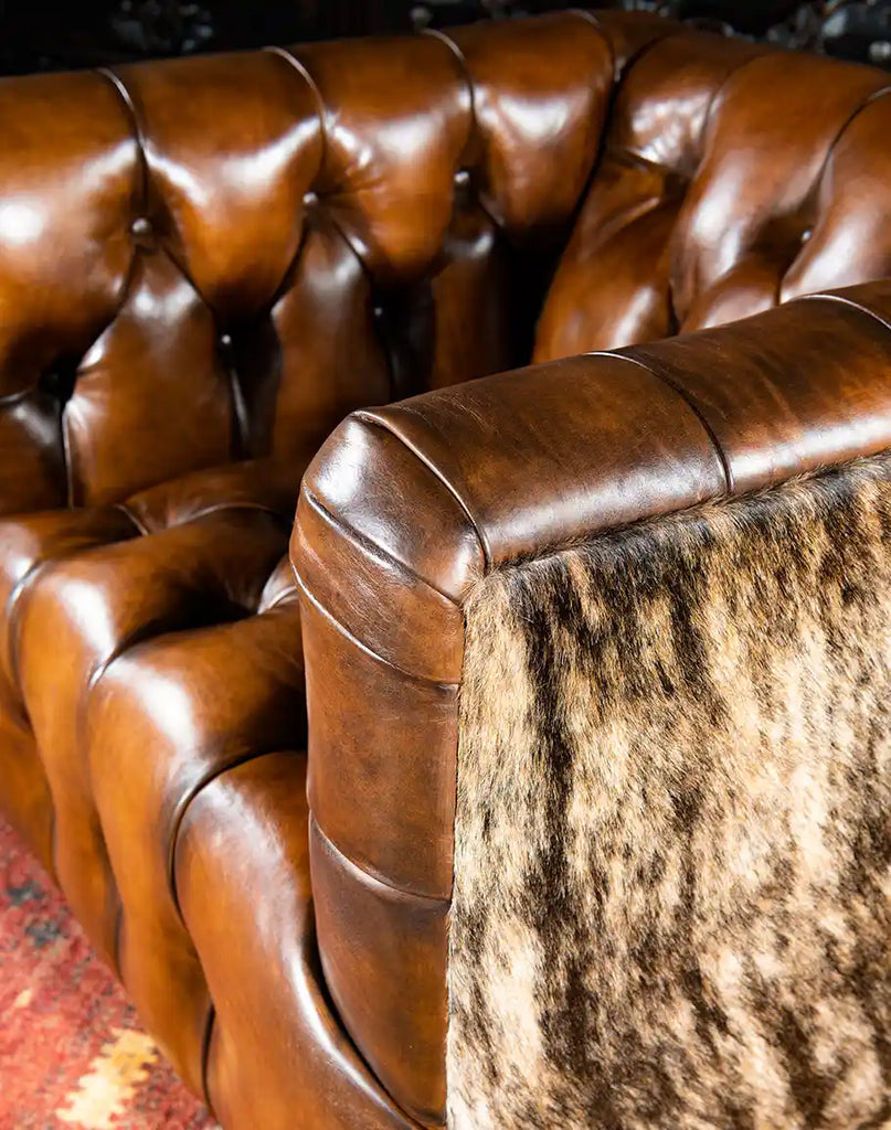 Detailed view of the armrest on the Bullet Club Chair, showcasing the seamless blend of leather and cowhide materials.