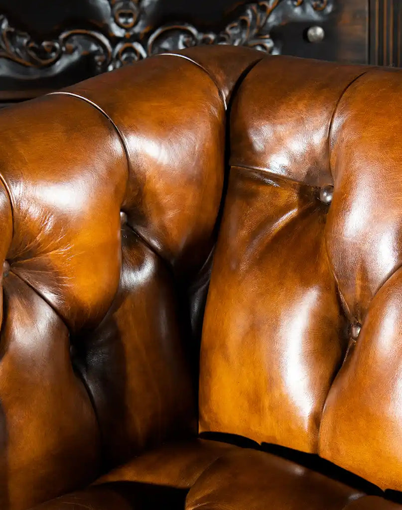Close-up shot of the deep button tufting on the Bullet Club Chair's hand-burnished leather interior.