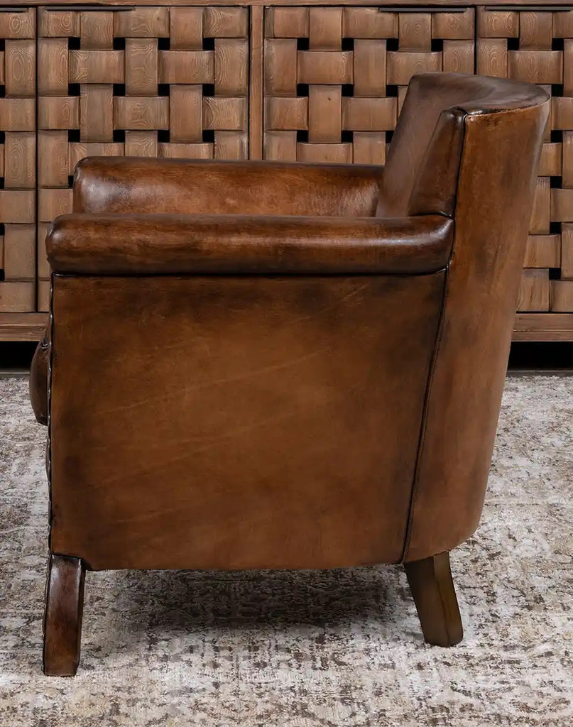 Brown leather armchair against a woven wooden panel background