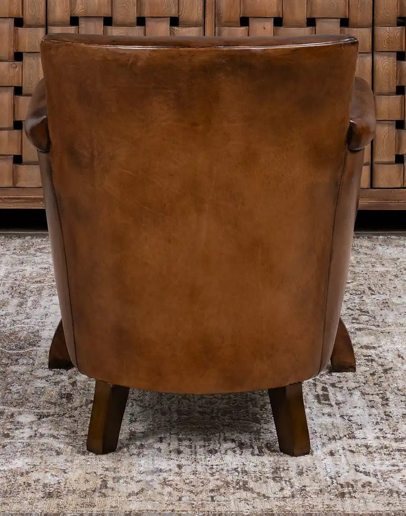 Brown leather armchair with a textured rug and wooden wall in the background