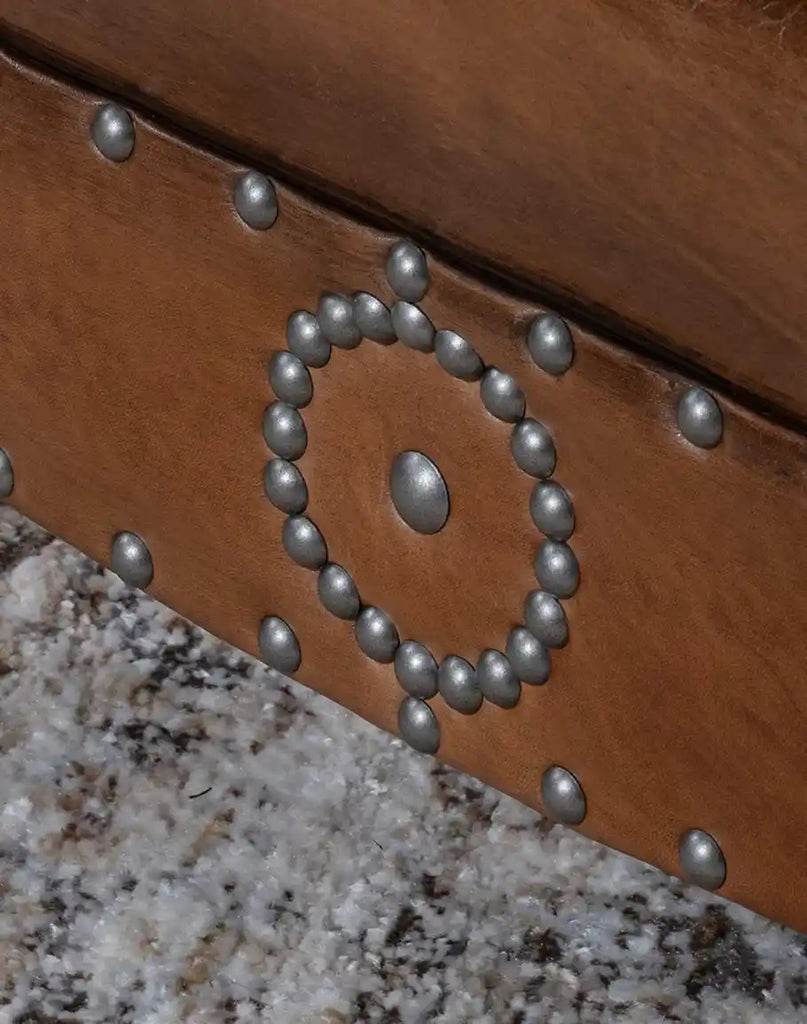 Close-up of a wooden belt with metal studs on a textured surface