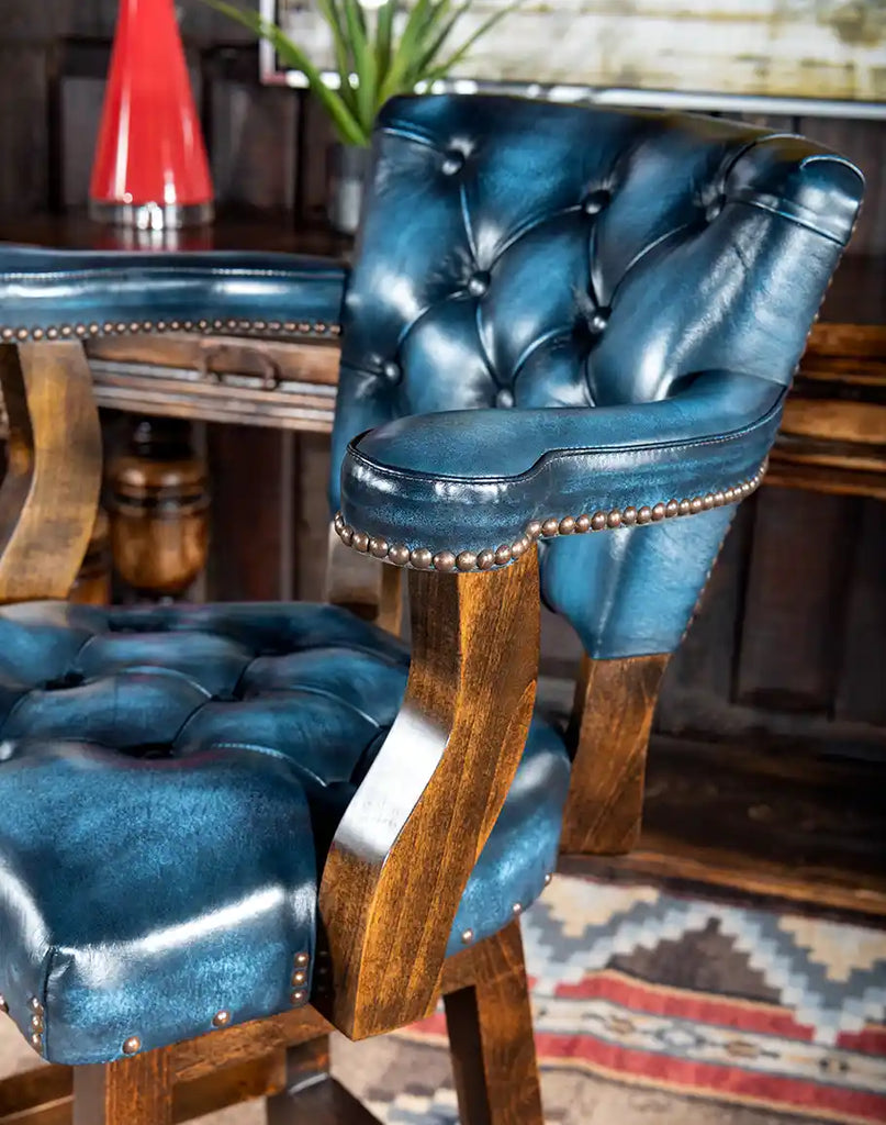Side angle of the Chisum Hondo Barstool highlighting padded arms and elegant button-tufted leather.
