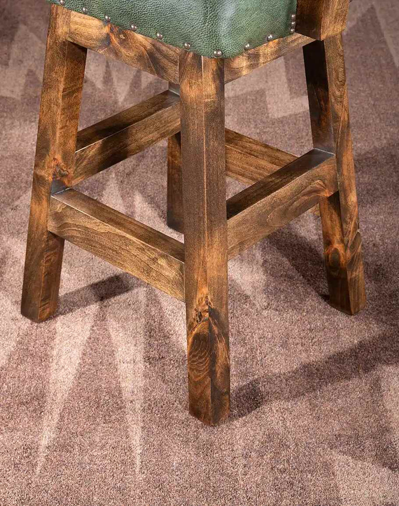 Detailed view of the sturdy wooden legs and base of the Chisum TX Olive Green Barstool for a timeless design.