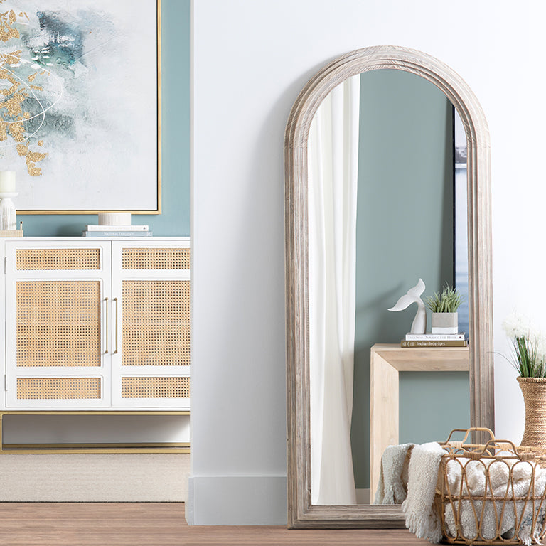 Arched floor mirror in a room with decor elements
