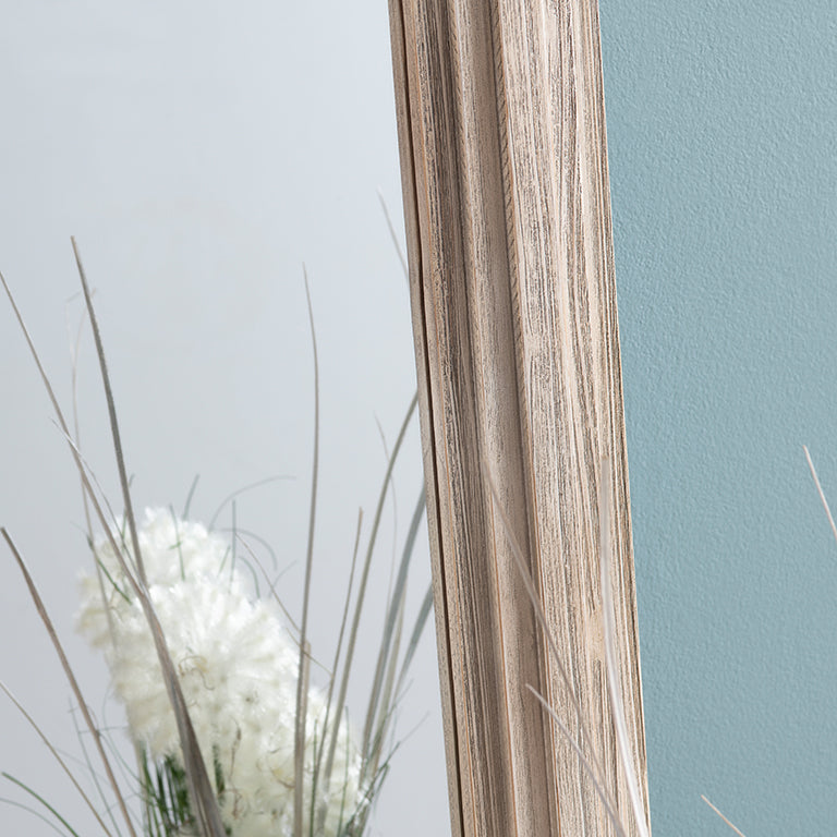 Close-up of a wooden stick with grass and flowers in the background