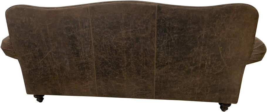 Back view of the Cora Sofa, upholstered in distressed Cora Pecan leather, featuring a classic camelback design and elegant turned wooden legs.