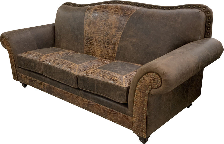 Side angle of the Cora Sofa, highlighting the sophisticated Gator Hornback Rustic Cognac leather accents and antique brass nail head trim.