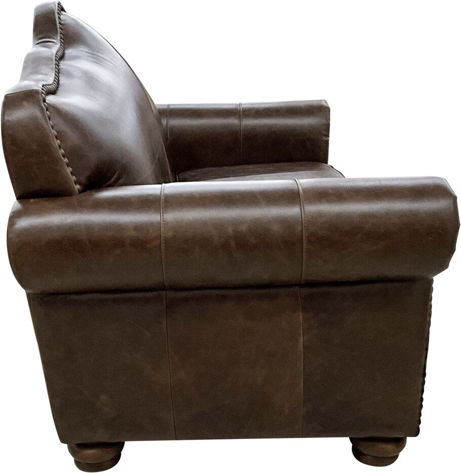 Side profile of the Crowned Camelback Loveseat, highlighting its rolled arms, intricate stitching, and premium leather craftsmanship.