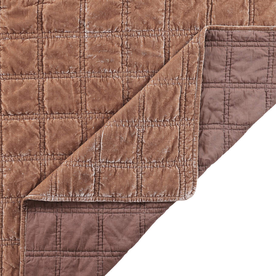 Close-up of the quilt's corner, displaying the precise stitching and plush velvet texture in a soothing dusty rose shade.
