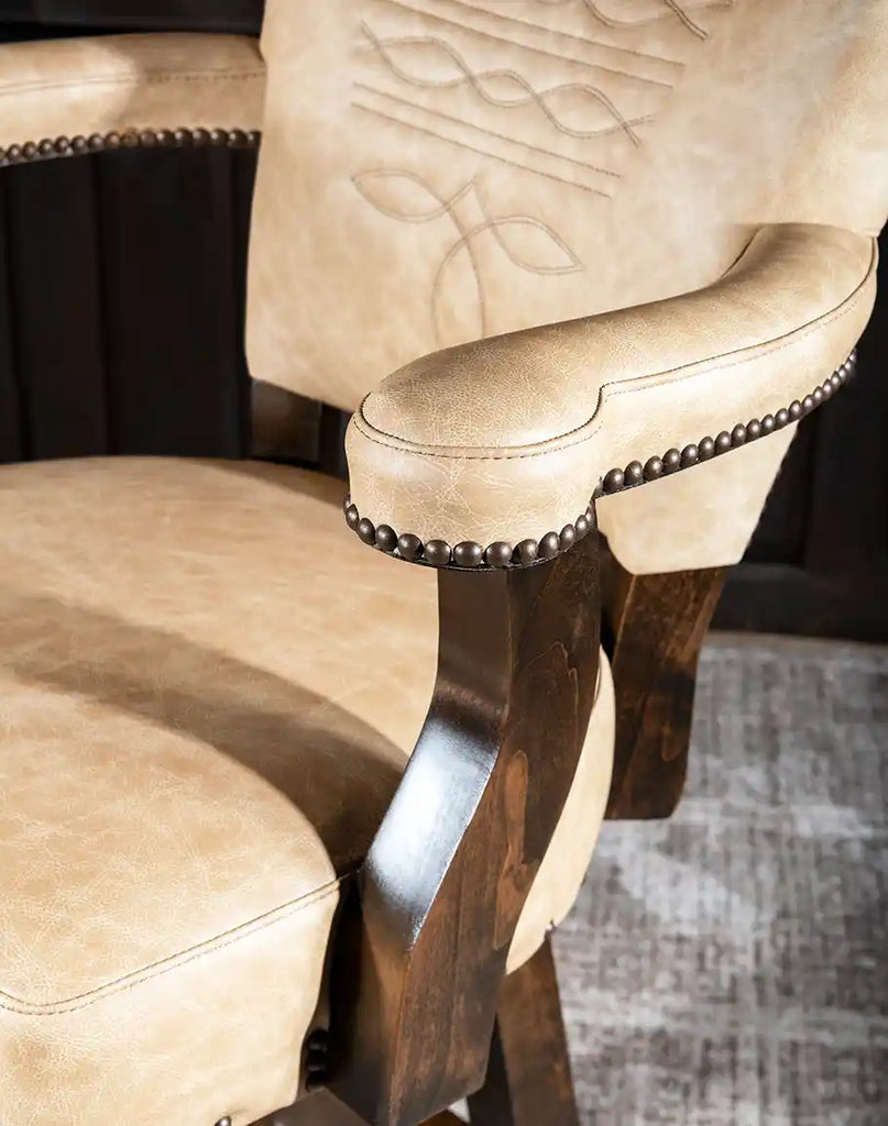 Close-up of the brass nailhead trim accentuating the Chisum TX Paraluman Barstool's backrest and arms.