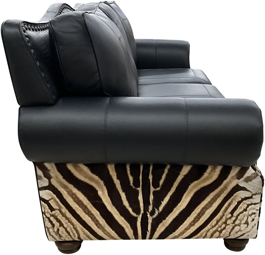 Side profile of the Exotic Zebra Sofa highlighting its curvaceous silhouette, black leather upholstery, and bold zebra hide detailing.