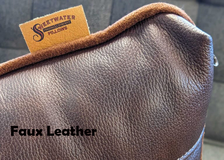 Corner of brown faux leather pillow with a brand tag on a blurred background