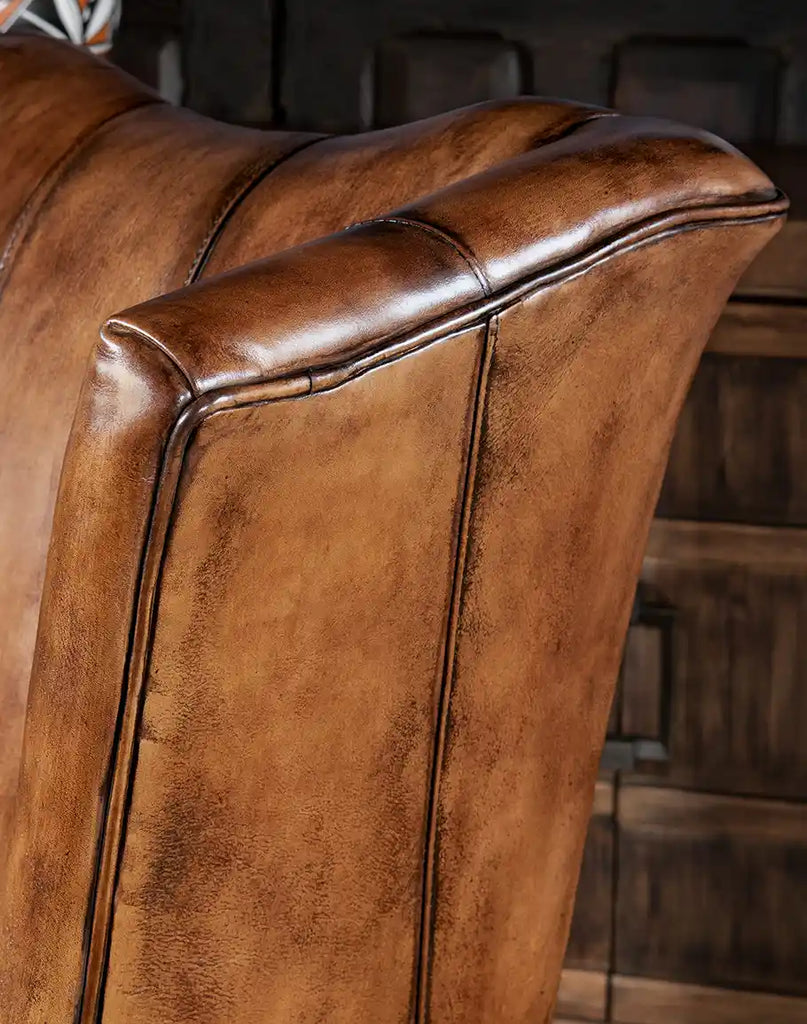A close-up showcasing the refined leather trimmings and expert craftsmanship on the chair’s frame.