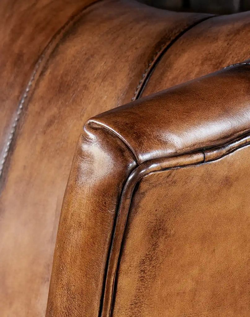 Detailed shot capturing the natural grain and supple quality of the hand-finished leather upholstery.