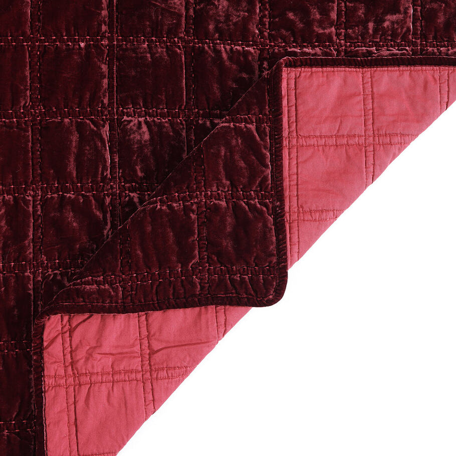 Close-up of the quilt's corner, displaying the precise stitching and plush velvet texture in a soothing garnet red shade.