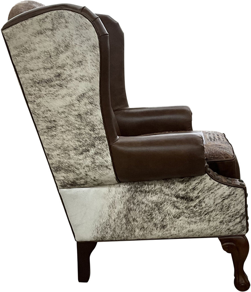 Side profile of the Honcho Wingback Chair showcasing its high-back winged design, cowhide-wrapped arms, and detailed leather accents.