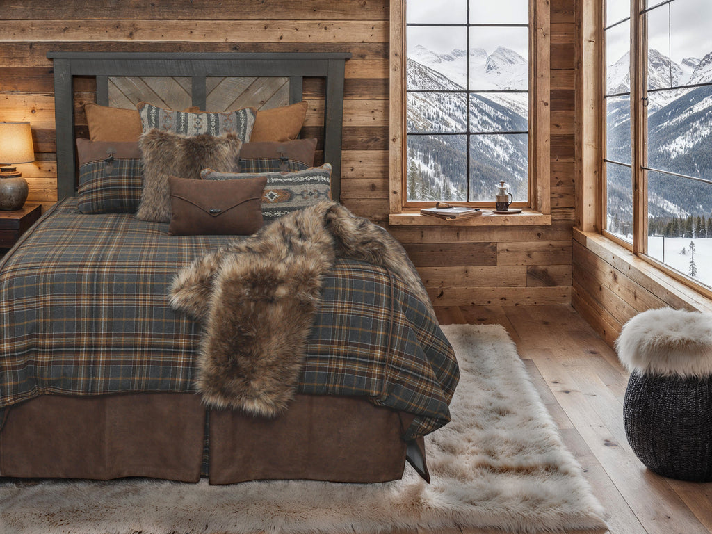 The Wooded River Kinsale Oxford Lodge Value Bedding Set is a luxurious ensemble featuring a classic plaid design in shades of navy blue, brown, tan, black, and hints of white. Crafted from a blend of wool, polyester, nylon, and acrylic, it offers both comfort and durability. The set includes a reversible duvet cover with a soft Chocolate Suede side, complemented by authentic leather accents and horn toggle button details for a touch of rustic elegance. Handcrafted by skilled sewers in the USA.