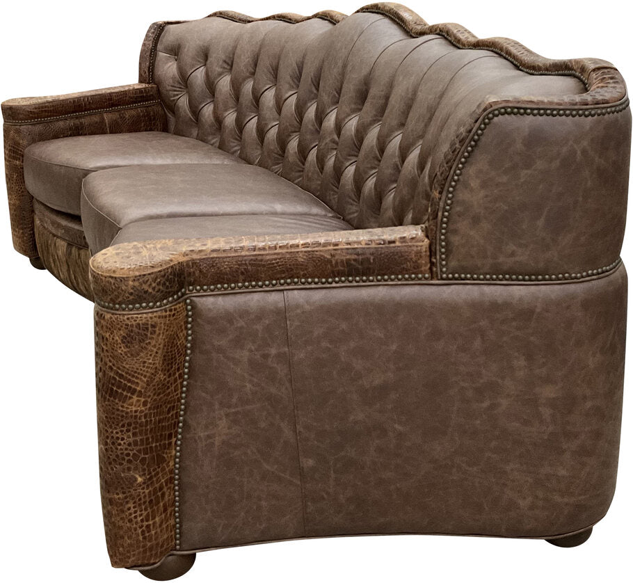Side profile of the Marshland Curved Sofa, showcasing its luxurious curved design, exotic cowhide bottom rail, and intricate nailhead trim.