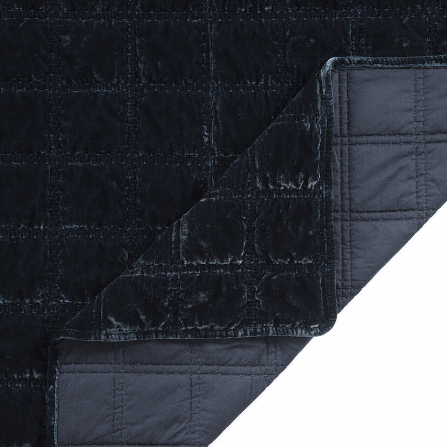Close-up of the quilt's corner, displaying the precise stitching and plush velvet texture in a soothing midnight blue shade.
