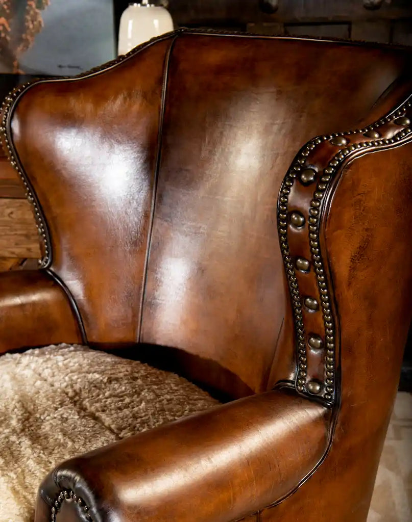 Side view displaying the chair’s sturdy frame, smooth leather armrests, and intricate stitching.