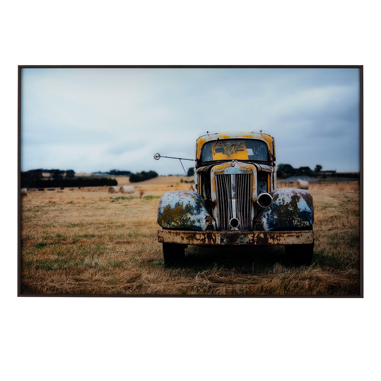Rustic old truck in a field with a framed border