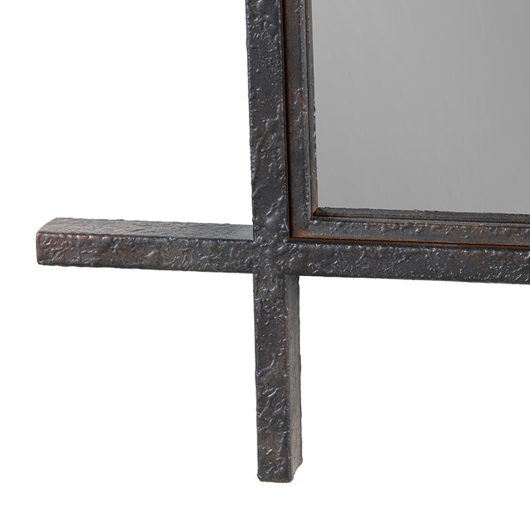 Close up of corner of decorative mirror with a textured metal frame on a white background
