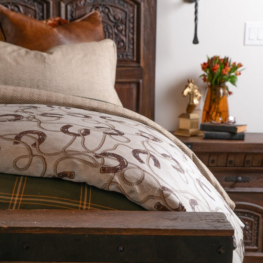 Corner of the Prieto Equestrian comforter folded back, revealing the smooth texture and quality of the cotton sateen material.