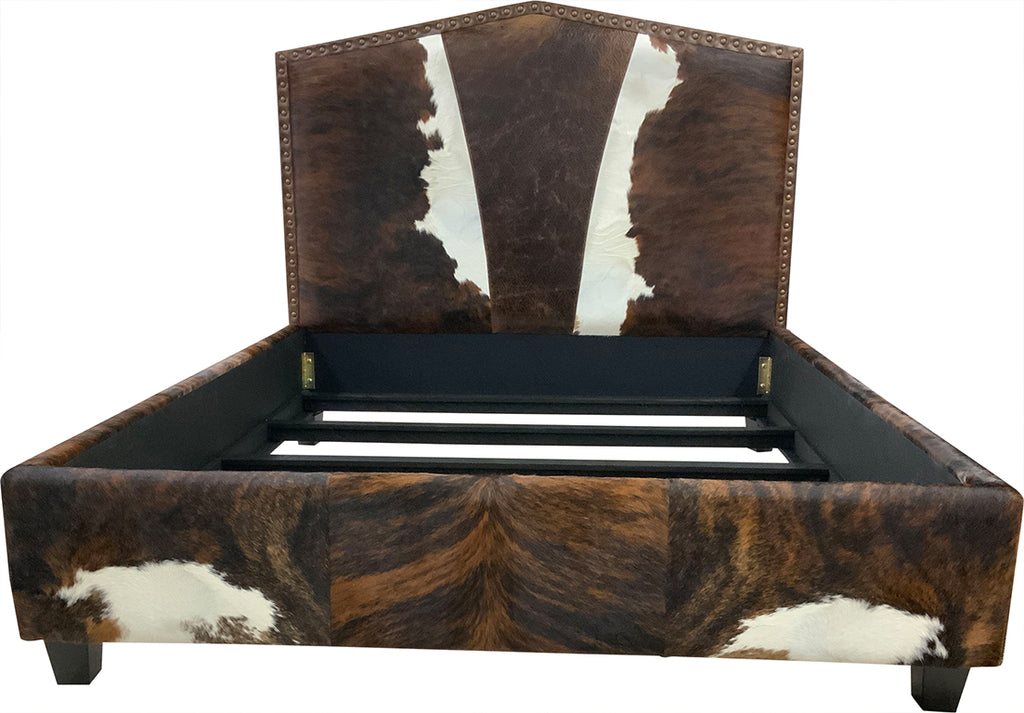 Front view of bed with cowhide leather headboard, footboard, and side rails on a white background