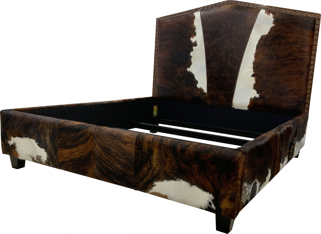 Angled view of bed with cowhide leather headboard, footboard, and side rails on a white background