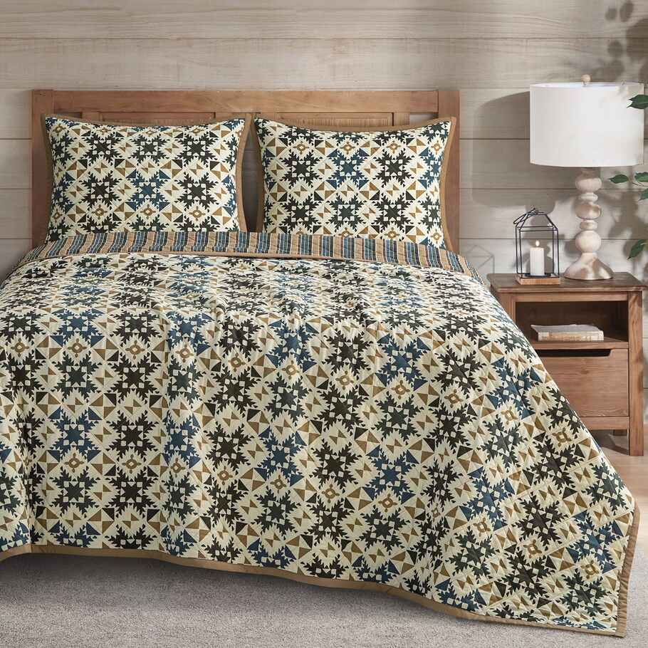 Ravenna Reversible Quilt Set styled in a rustic bedroom with wooden accents, emphasizing its Southwestern charm.