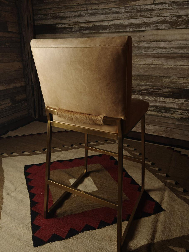 Rear view of the Roaring Fork Valley Barstool, displaying the smooth Burnham Sunset leather backrest and the clean lines of the brass frame.